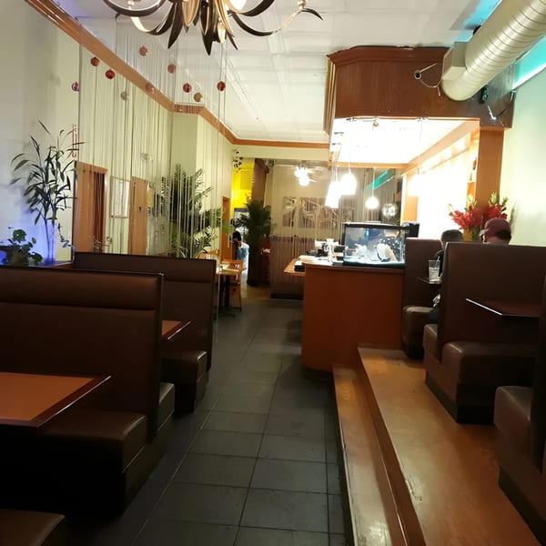 Restaurant interior with brown booths, dark tiled floor, and a counter with a fish tank.